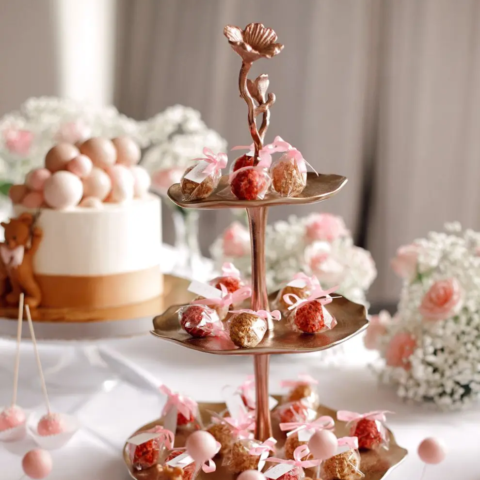 Šokolādes trifeles, kas iesaiņotas plastmasas maisiņā vai plastmasas kastē īpašā kūku statīvā